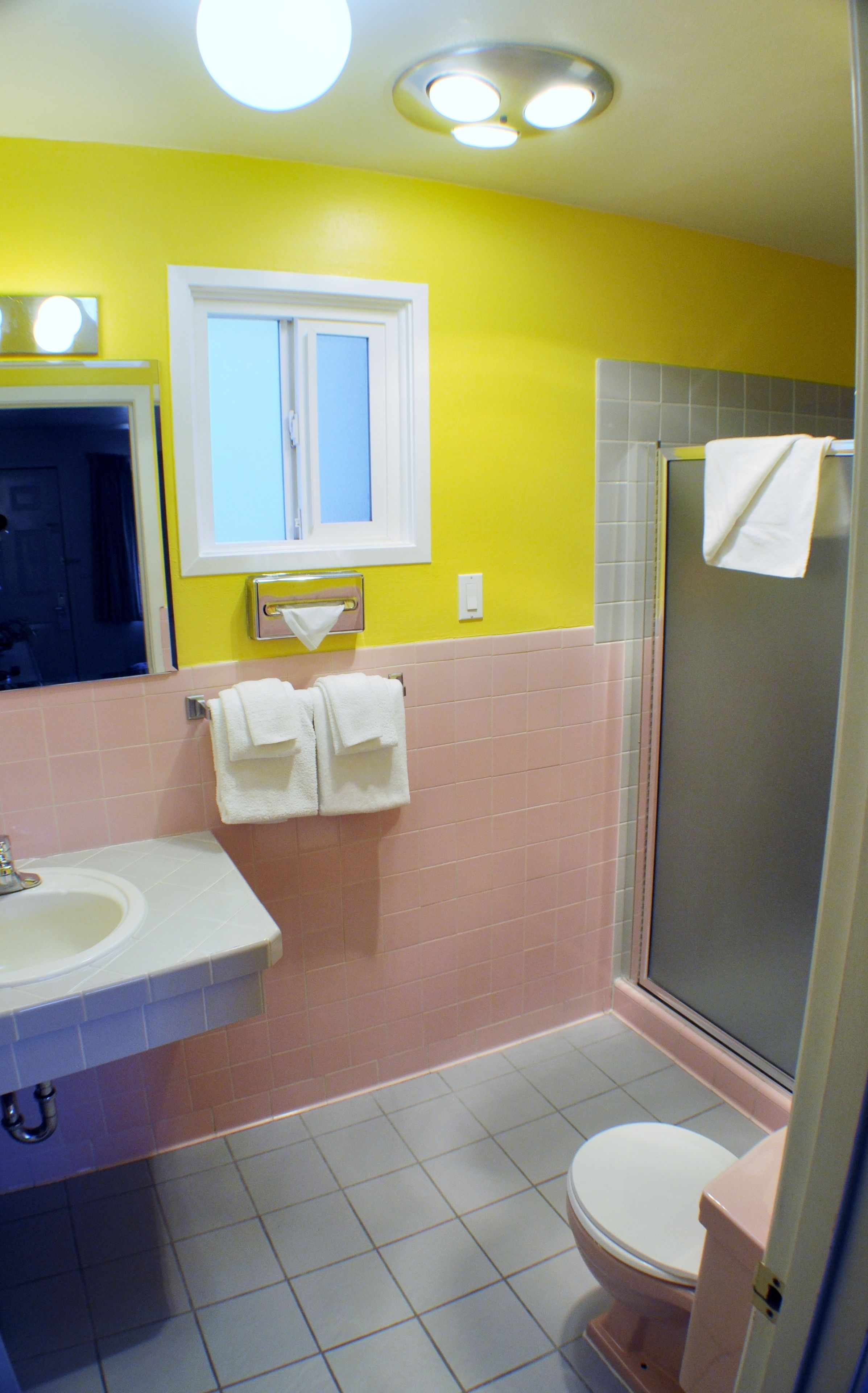 A bathroom with a sink, mirror, and a shower.