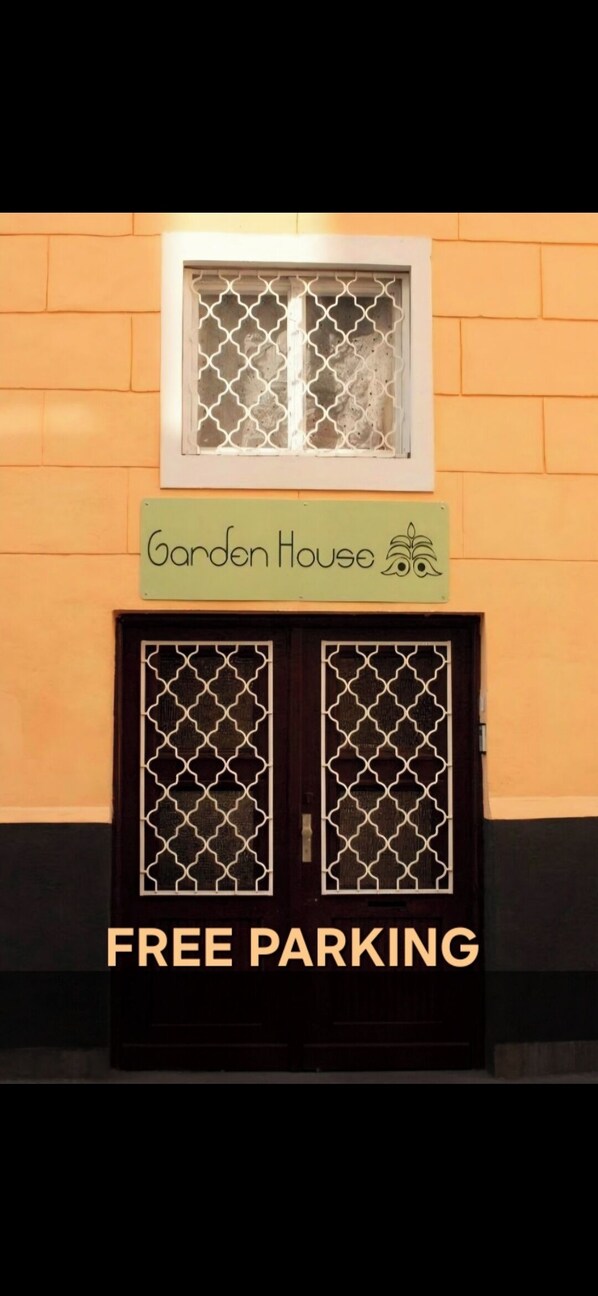A building with a sign reading "Garden House" and a "FREE PARKING" sign below the entrance. - Garden House Budapest (Budapest)