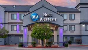 A hotel named 'Best Western' with a modern architectural design, featuring a prominent entrance and a landscaped front yard.