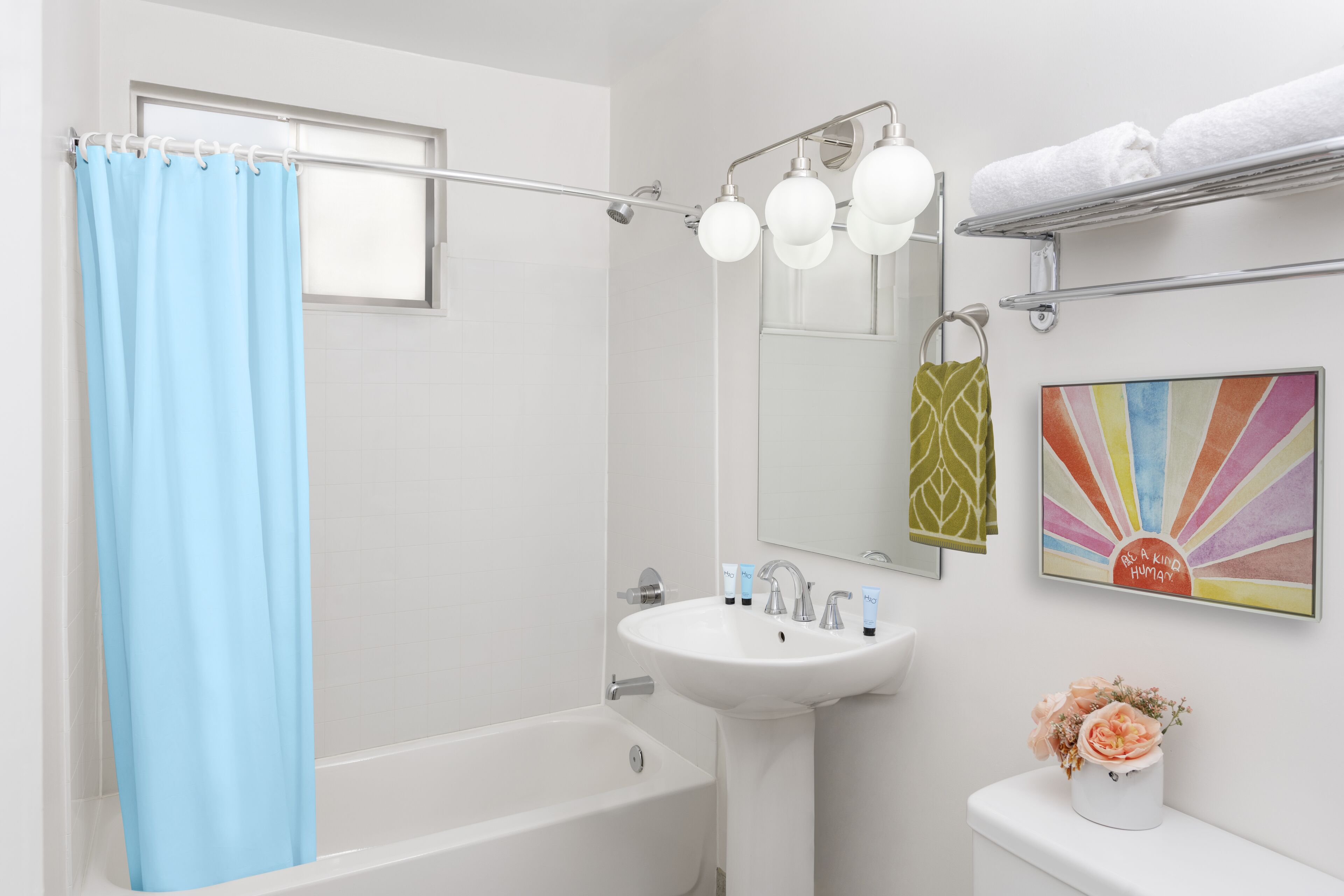 A bathroom with a bathtub, sink, and a shower curtain.