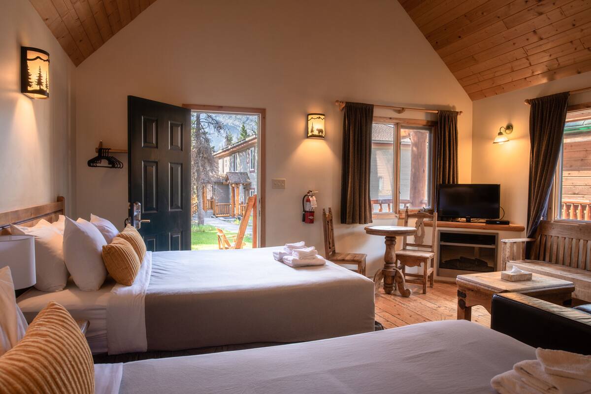 Une chambre d’hôtel avec deux lits, une télévision, une petite table et une chaise.
