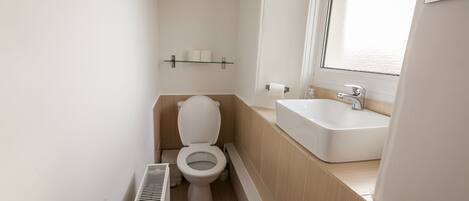 Un baño pequeño y moderno con inodoro, lavabo y bañera.