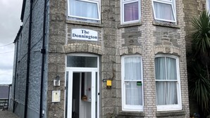 Un edificio de dos pisos con fachada de piedra, un cartel que dice "The Donington" y una puerta con el número "43" encima.