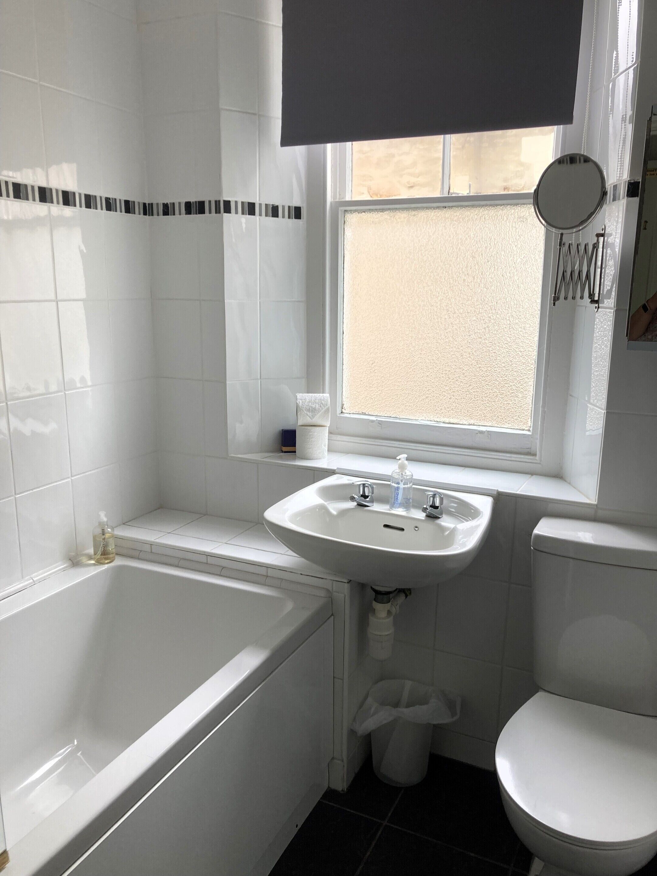 A bathroom with a white bathtub, sink, and toilet.