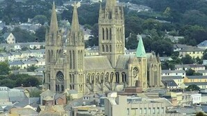 Una catedral histórica con dos torres gemelas, un gran rosetón y un techo verde.