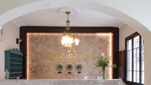 A reception area with a chandelier, a wall-mounted clock, and a sign reading "Hotel Señorial". - Hotel Señorial (Lima)