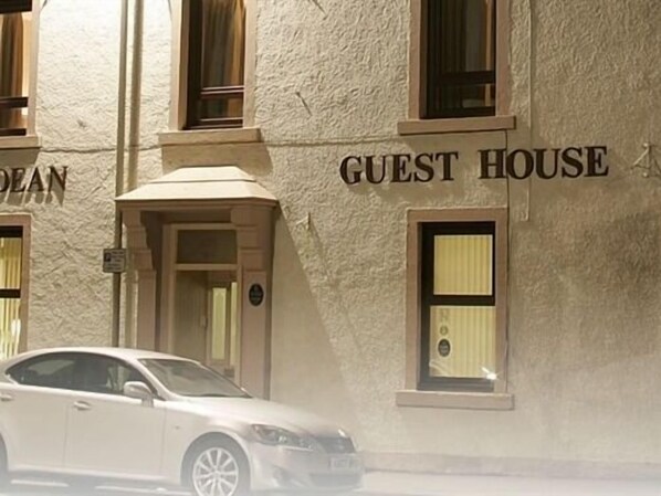A building labeled "GUEST HOUSE" with a classic architectural style, featuring a prominent entrance and a car parked in front. - Hebridean Guest House (Stornoway)