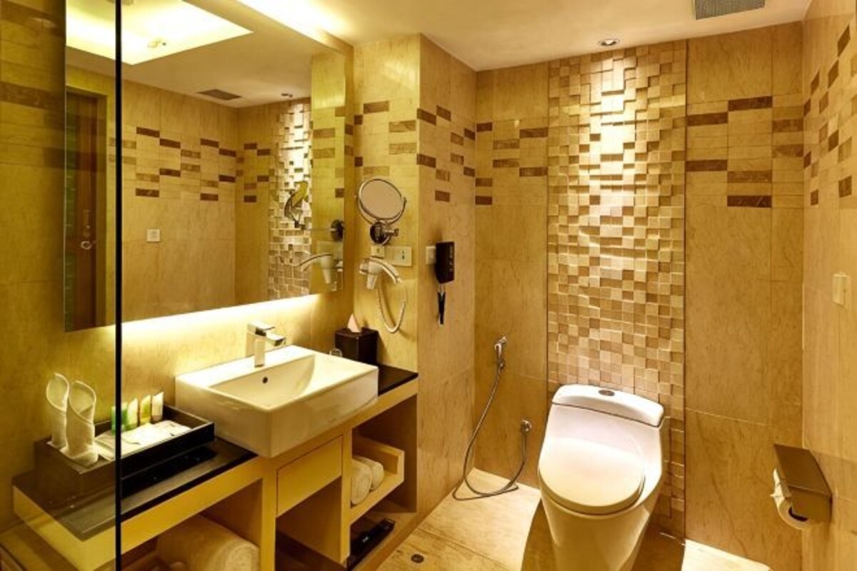 A bathroom with a sink, mirror, toilet, and shower.