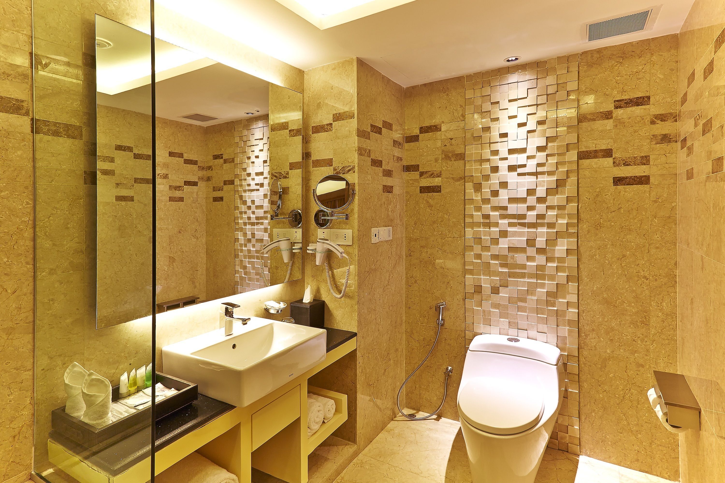 A modern bathroom with a large mirror, a sink, a toilet, and a shower area.