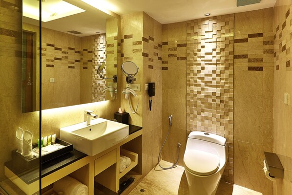 A modern bathroom with a sink, mirror, and toilet.