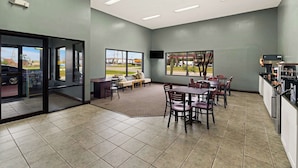 A modern restaurant with a dining area, kitchen, and large windows offering views of the outside. - SureStay by Best Western Gulfport (Gulfport)