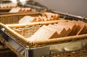 Een metalen dienblad met sneetjes brood in een rieten mand.