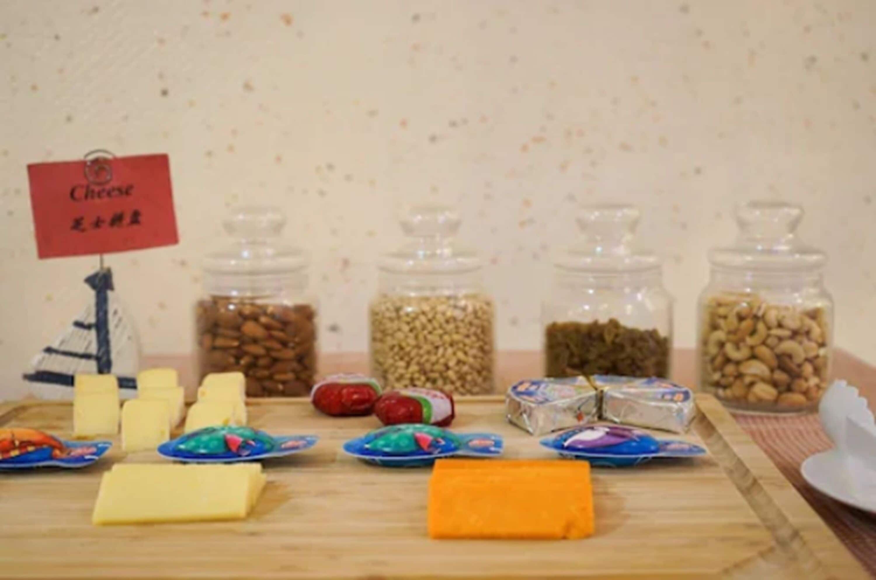 A table with various food items including cheese, nuts, and packaged snacks.