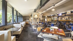 A spacious restaurant with high ceilings, large windows, and a variety of seating options including booths and tables. - Burvale Hotel (Vermont South)