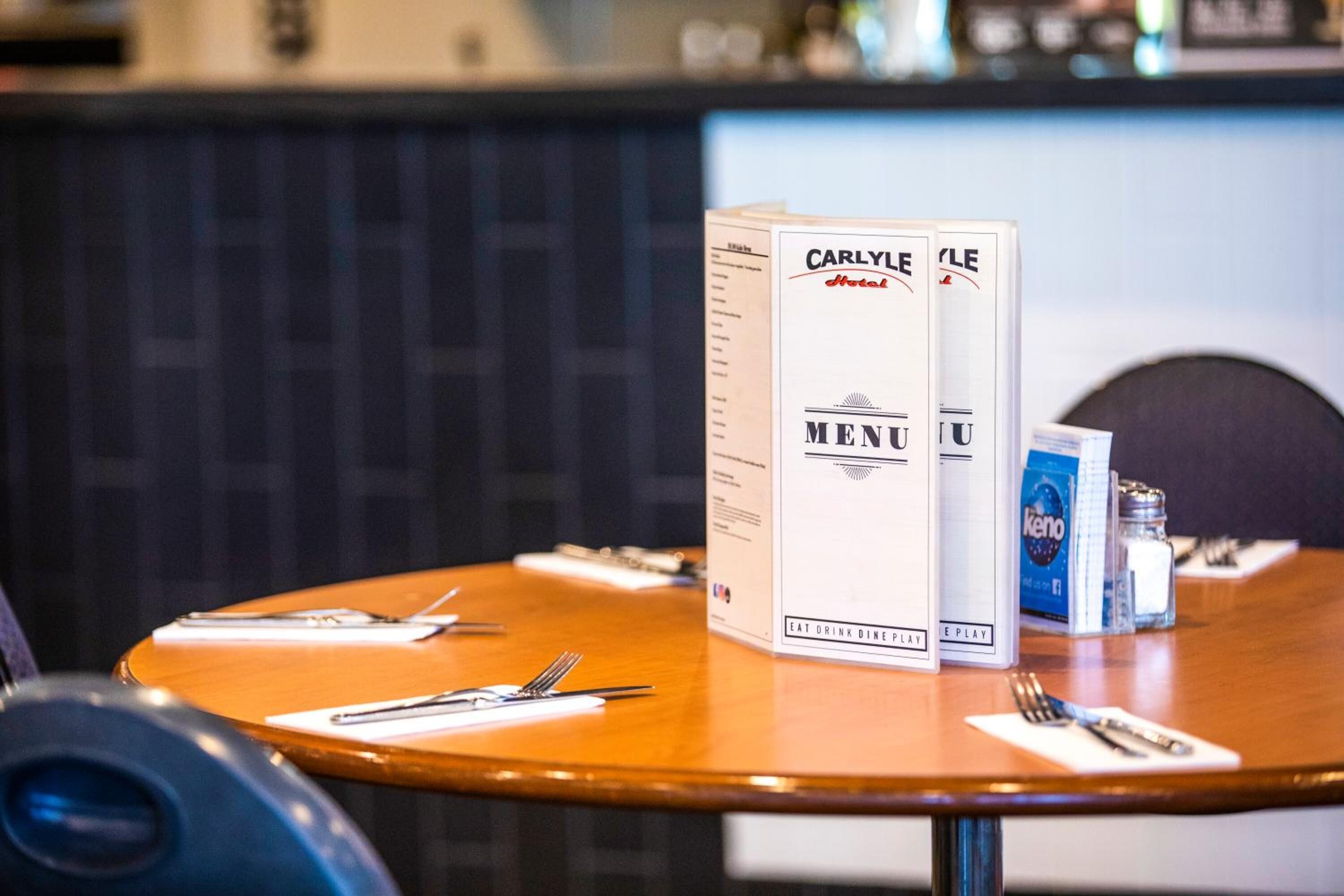 A table with a menu and a beverage dispenser.