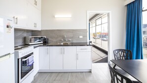 Una cocina moderna con armarios blancos, microondas integrado y estufa.