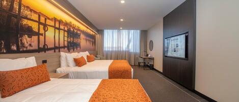 A hotel room with two beds, a desk, a chair, a TV, and a large window.