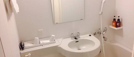 A bathroom with a sink, mirror, towel rack, and two shelves with toiletries.