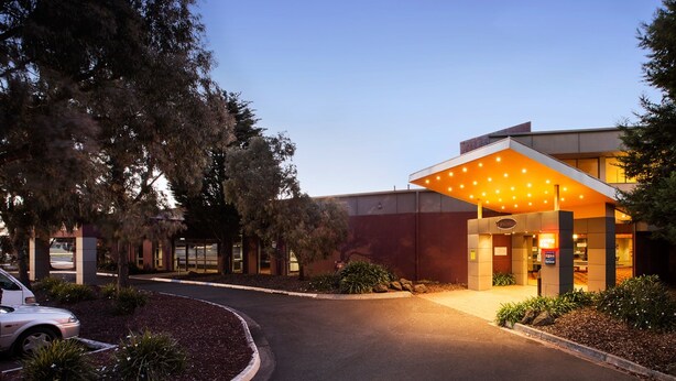 A hotel entrance with a covered walkway and a car parked in the driveway. - Nightcap at Coolaroo Hotel (Coolaroo)