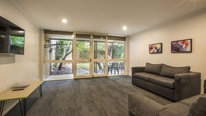 A modern living room with a grey sofa, a small table, and two framed artworks on the wall. - Nightcap at Coolaroo Hotel (Coolaroo)