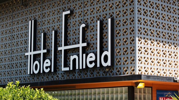 Ein Hotel-Schild mit einem geometrischen Muster und dem Namen 'Hotel Enfield'.