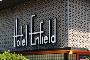 Een hotelschild met een geometrisch patroon en de naam 'Hotel Enfield'.