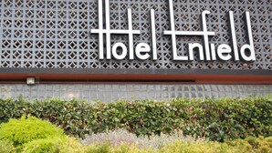 Ein Hotelschild mit einem geometrischen Muster und dem Namen 'Hotel Enfield'.
