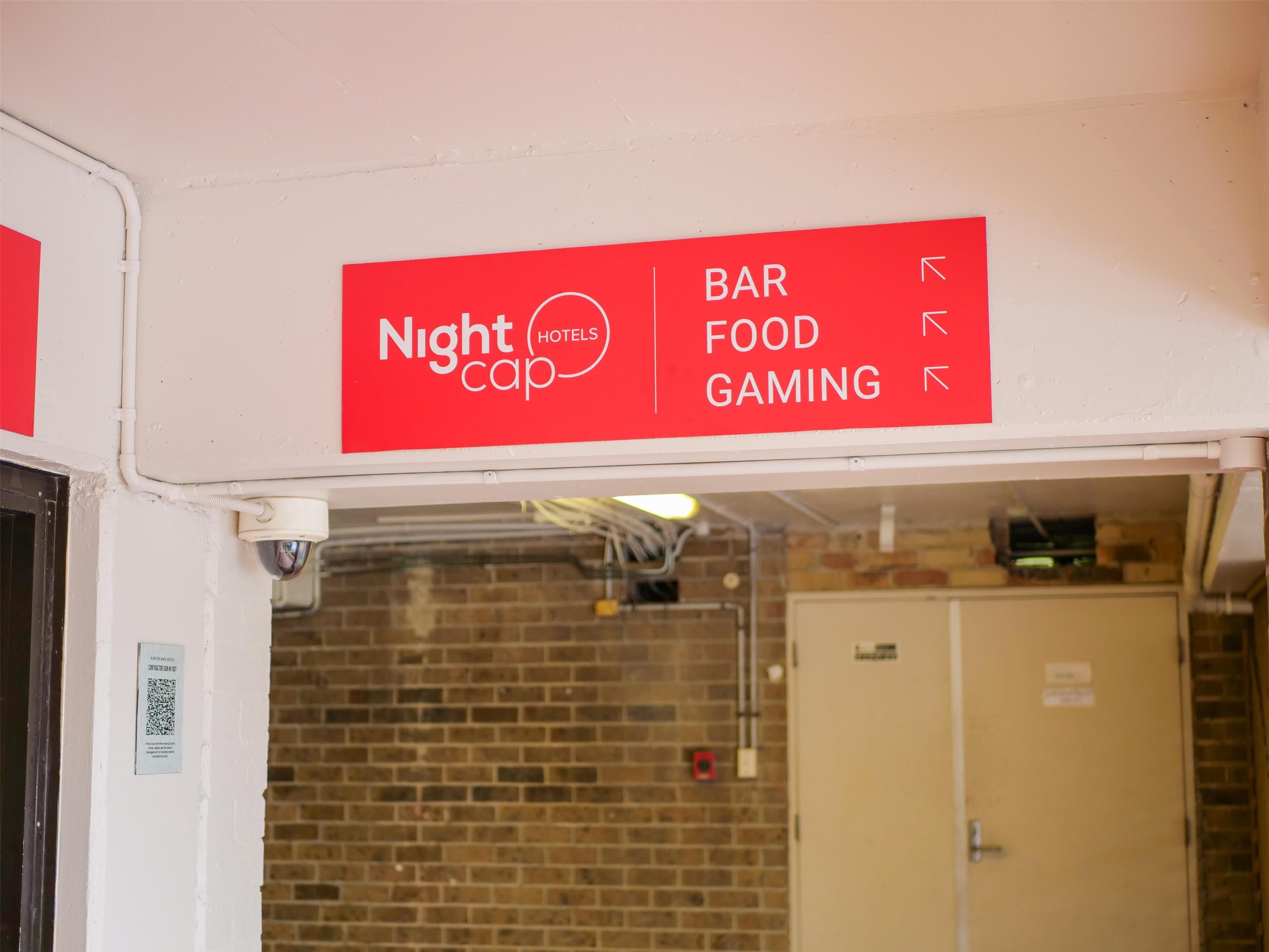 A sign indicating directions to the Nightcap Hotels' bar, food, and gaming areas.