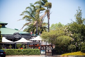 A restaurant named "The Swinging Pig" with outdoor seating and a green roof.