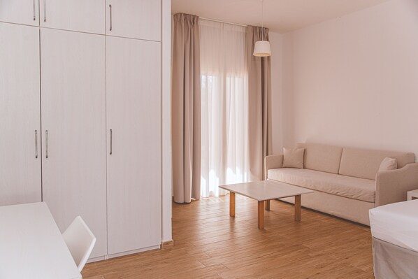 A minimalist living room with a sofa, a coffee table, and a wardrobe.