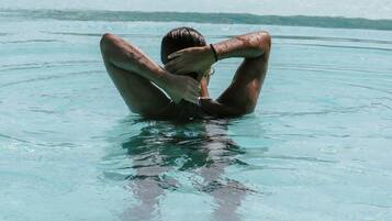 A person sitting in a pool with clear water.