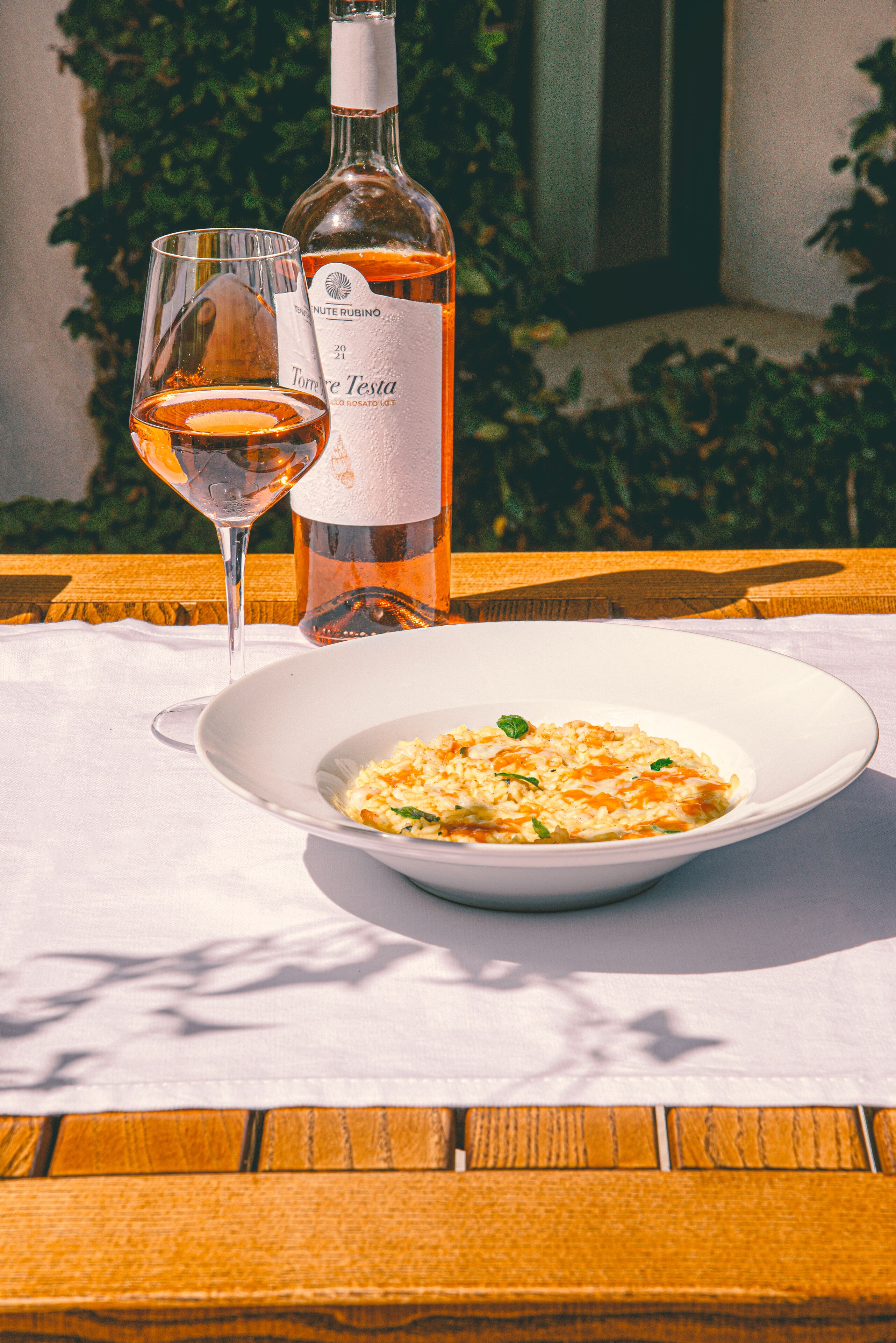 Une table avec un bol de nourriture et une bouteille de vin.