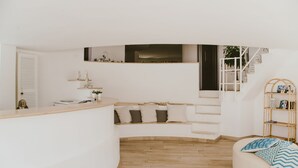 A modern, white interior with a curved bench, a wooden floor, and a staircase. - Residence Altair-Serra Alimini 3 (Otranto)
