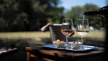 Two glasses on a tray with a bottle pouring into one.