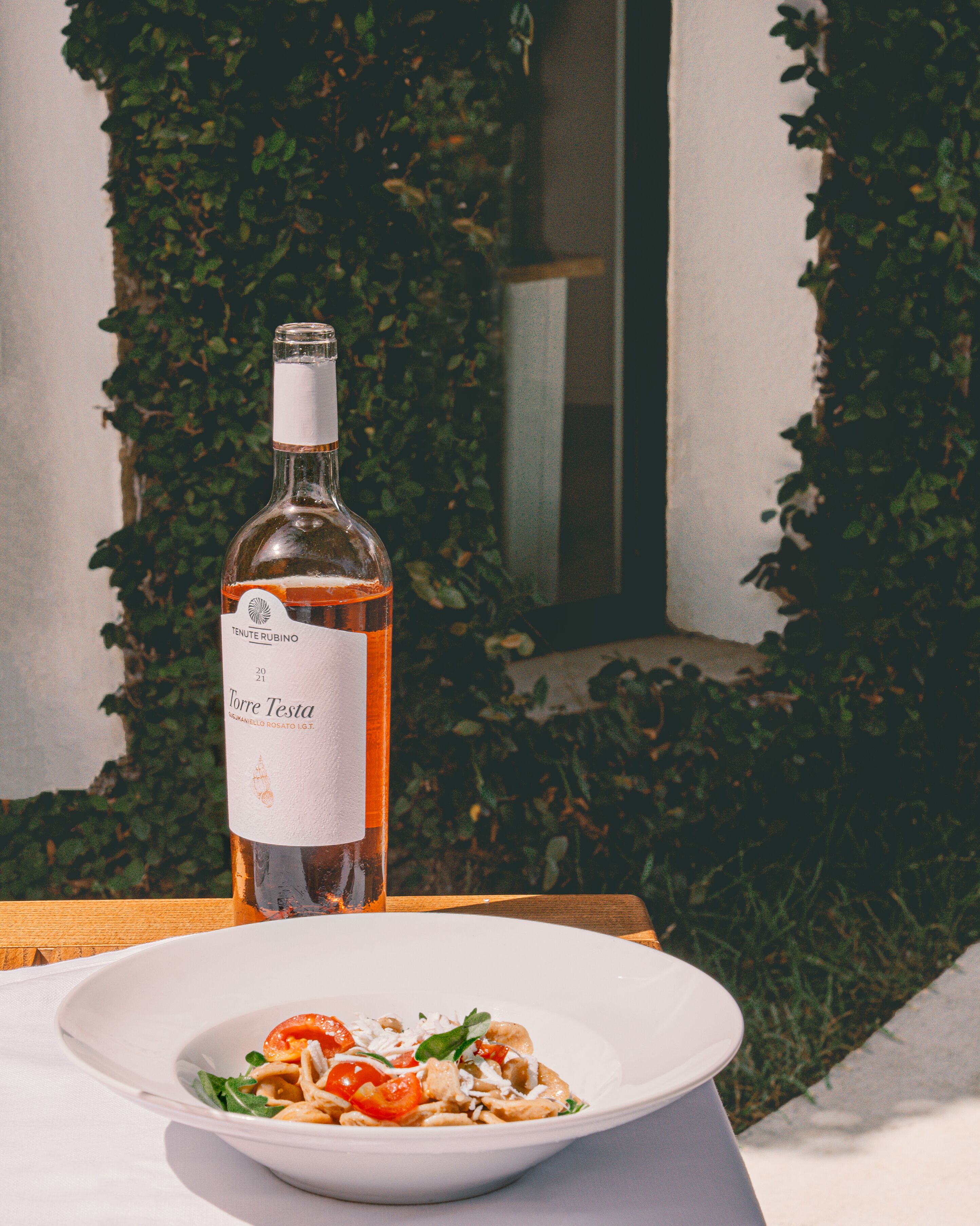 Une bouteille de vin et une assiette de nourriture sur une table.