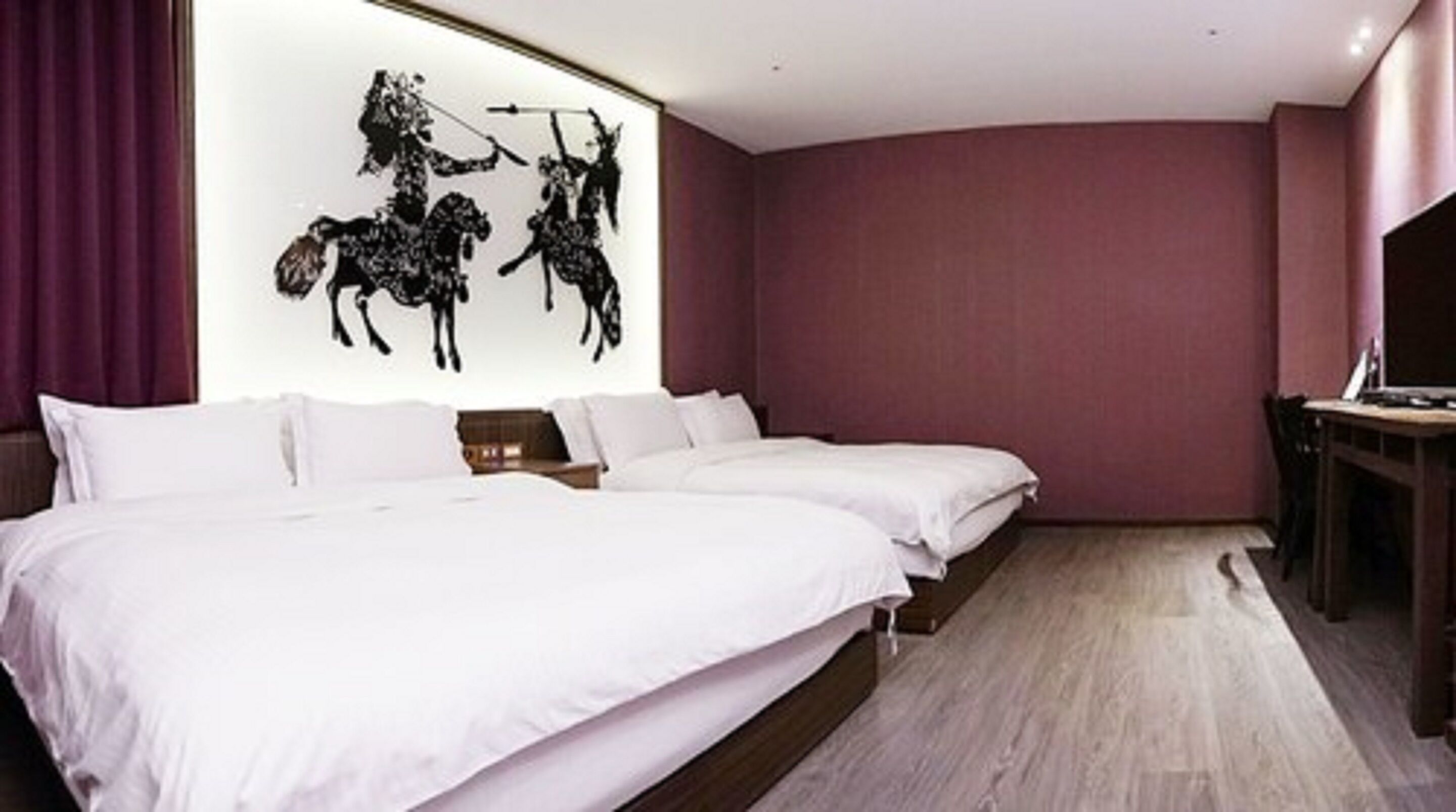 Une chambre d’hôtel avec un grand lit, un bureau et une œuvre d’art accrochée au mur.