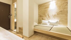 Un dormitorio moderno con cabecera de madera, cama con ropa de cama blanca y suelo de madera.