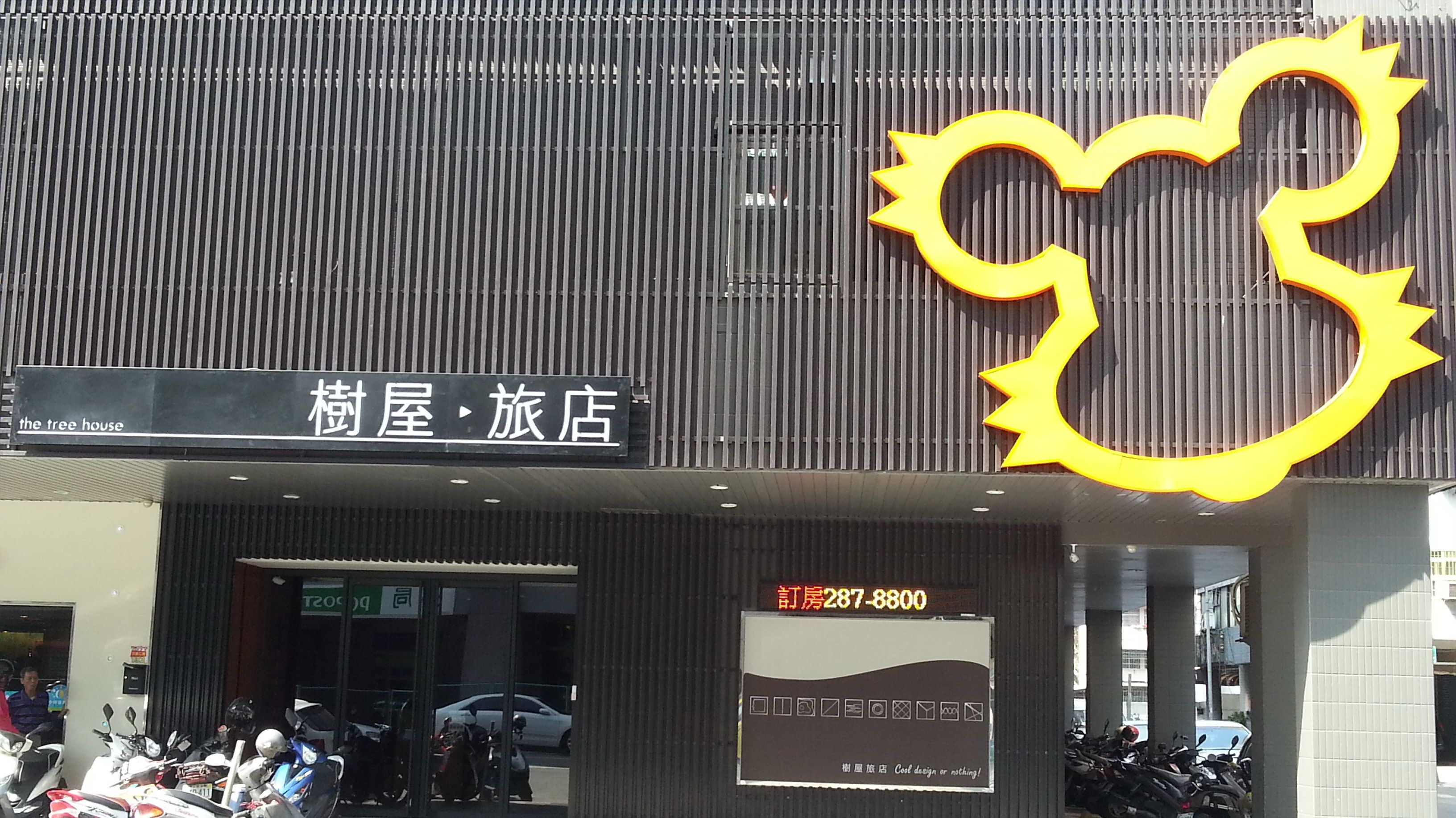 A building with a sign reading "The Tree House" and a large yellow sun-shaped decoration.