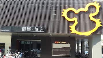 A building with a sign reading "The Tree House" and a large yellow sun-shaped decoration.
