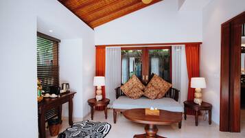 A modern living room with a sofa, two side tables with lamps, a coffee table, and a patterned rug.