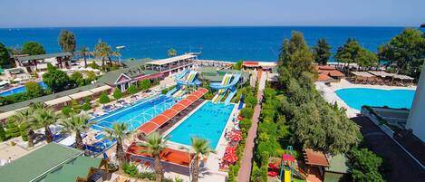 Una piscina al aire libre, sombrillas, tumbonas