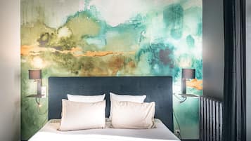 Une chambre dotée d’un grand lit, de deux lampes de chevet et d’une décoration murale abstraire à motifs.
