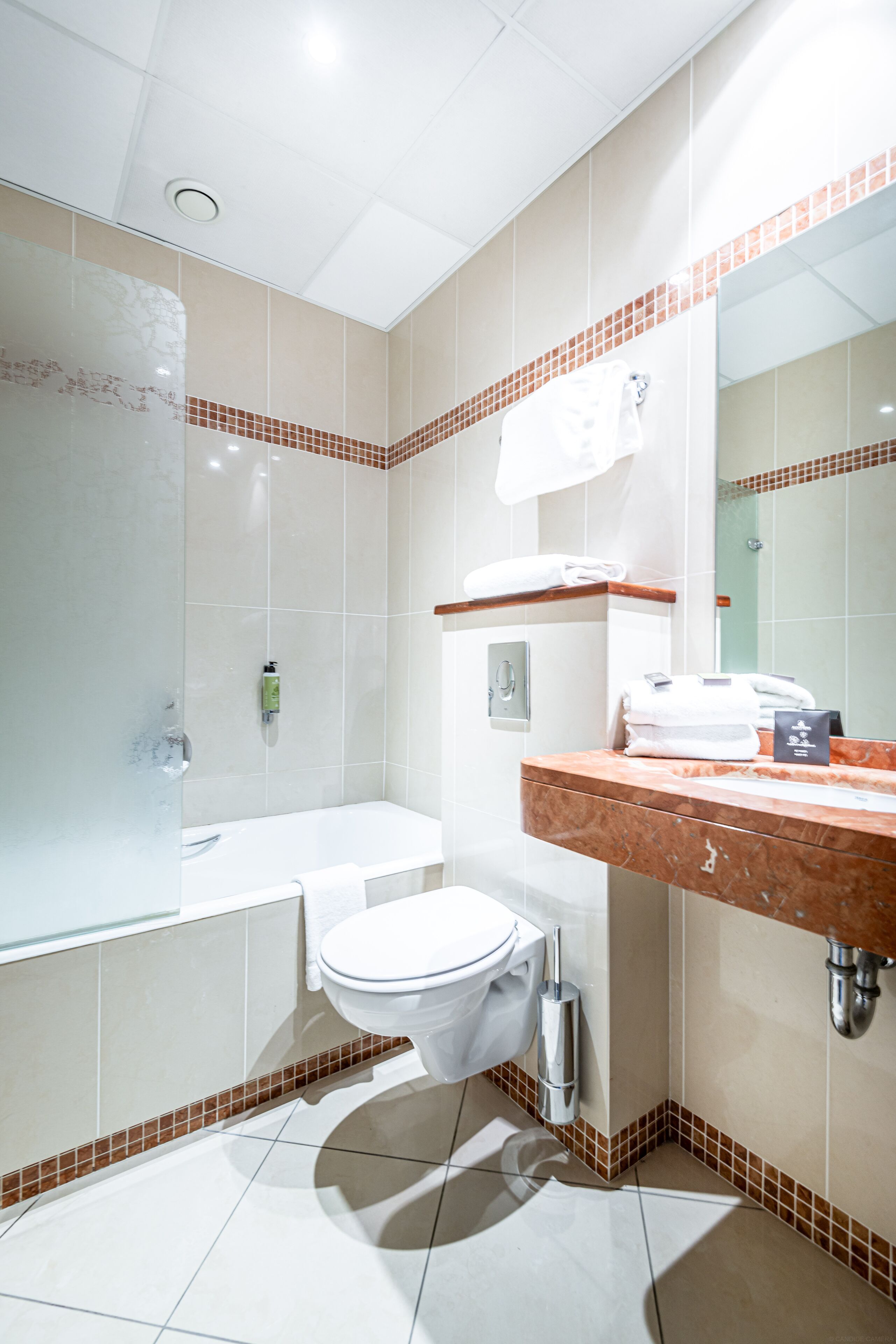 A modern bathroom with a bathtub, toilet, and vanity.