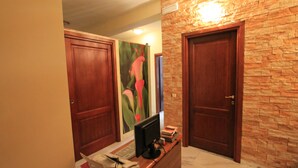 A reception area with a desk, computer, and framed artwork on the wall. - Le Terrazze del Vaticano (Rome)
