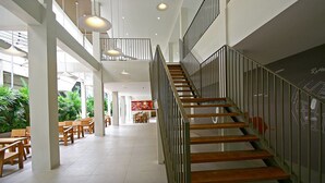 Ein großzügiger Innenbereich mit Treppe, Holzboden und moderner Pendelleuchte.