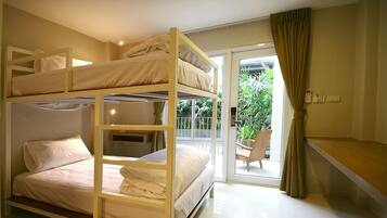 A bunk bed room with a balcony and a chair outside.