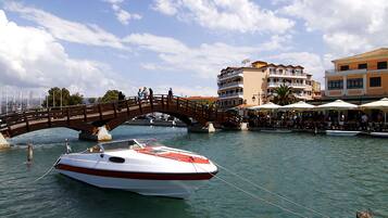 Een boot afgemeerd in een jachthaven, met een houten brug op de achtergrond.