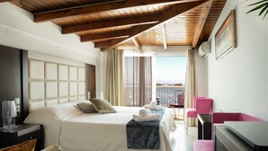 A hotel room with a bed, a desk, a chair, and a balcony with a view.