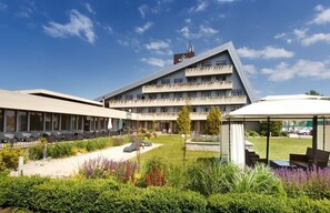 A modern hotel with a multi-story structure, outdoor seating areas, and a well-maintained garden. - Eden Resort & SPA (Mielno)