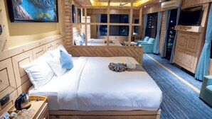 Una habitación de hotel con una cama, un televisor, una ventana y un cuadro en la pared.
